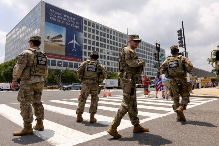 National Guard members patrol a street, ensuring information   adjacent   a authorities  gathering  with a ample  aviation-themed banner