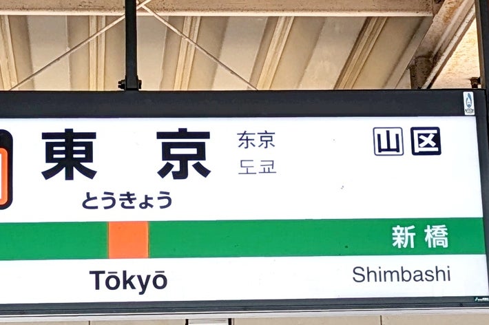 東京駅のホームに停車中の電車と駅名標が見える様子。