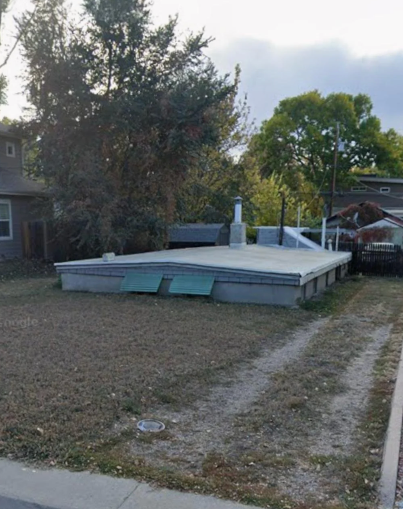 House built mostly underground with lone the extortion visible, blending into a grassy yard