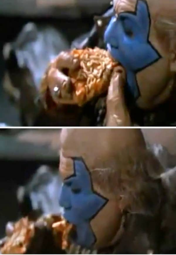 John Leguizamo with blue star face paint enthusiastically eats a slice of pizza