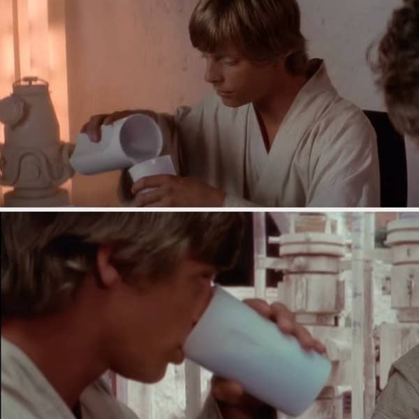 Luke Skywalker in a robe drinks from a plastic cup, seated indoors