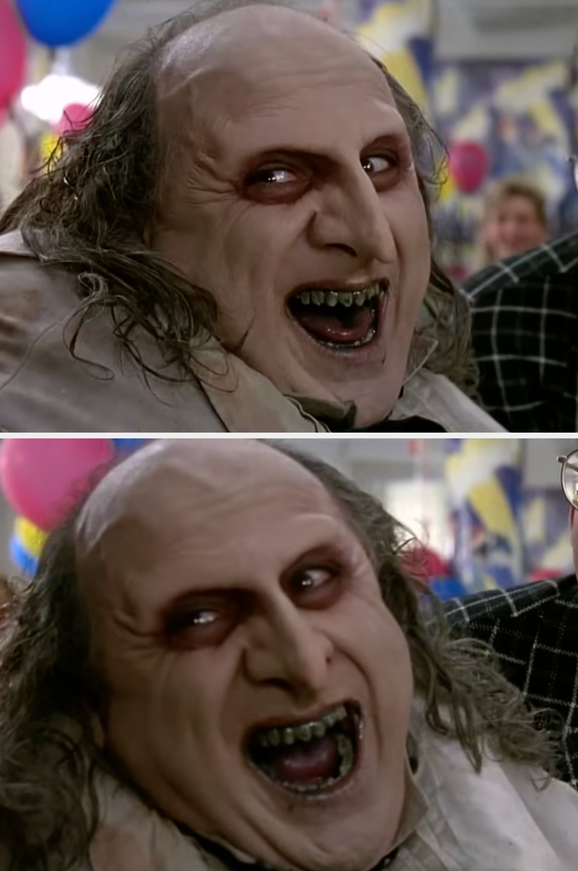 Danny DeVito with Penguin makeup grins widely, showing darkened teeth