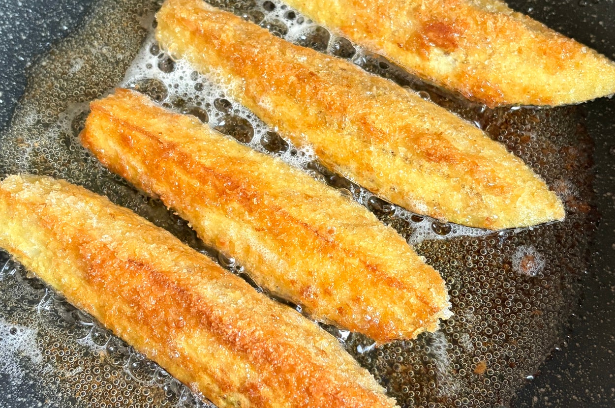 フライパンで揚げられているなす。