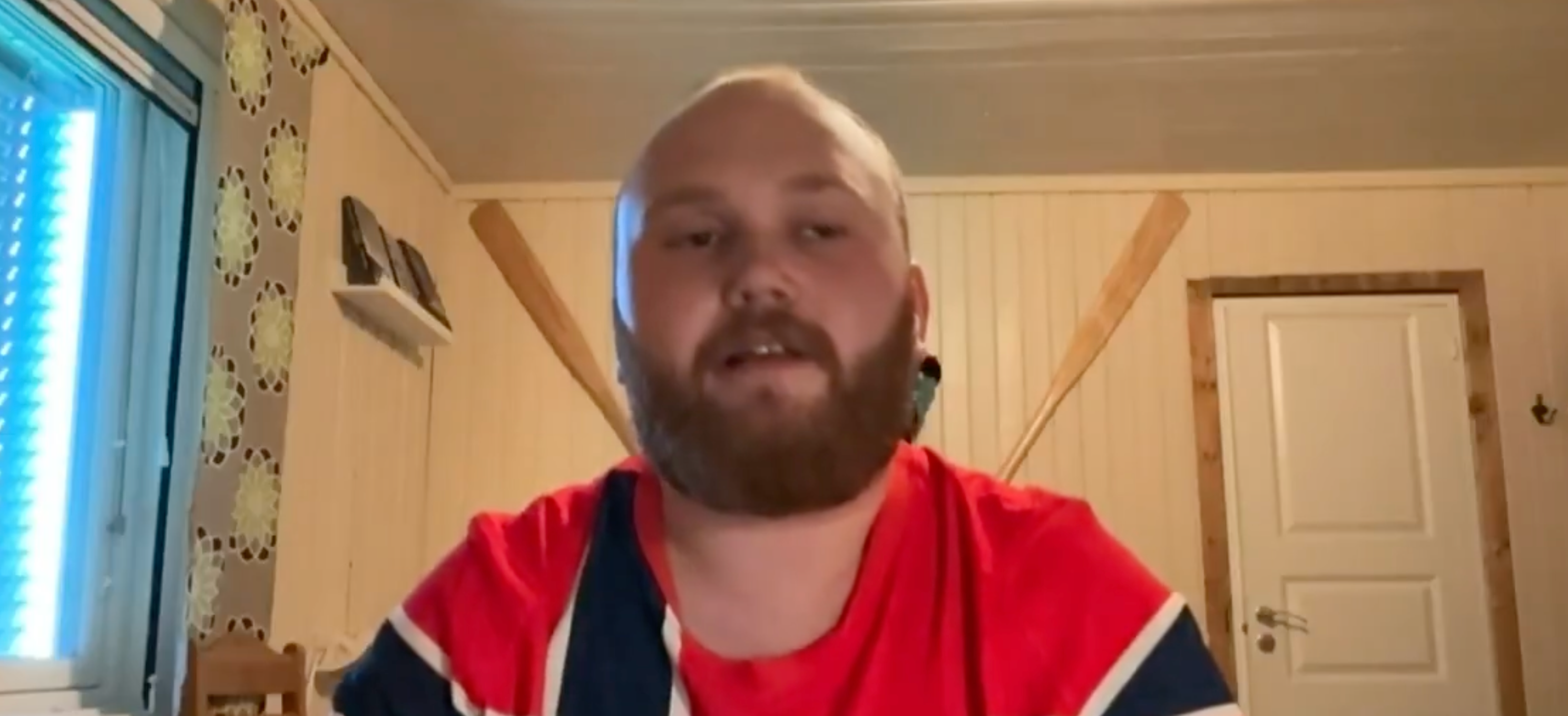 Person i rom med treårer på veggen, snakker direkte til kamera