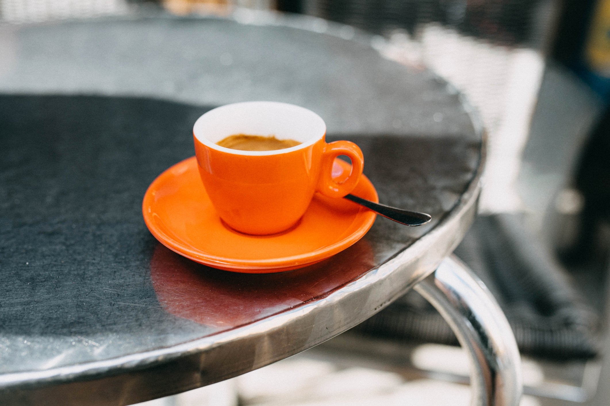 Espresso in a cup on a café table outside, capturing a relaxed travel atmosphere