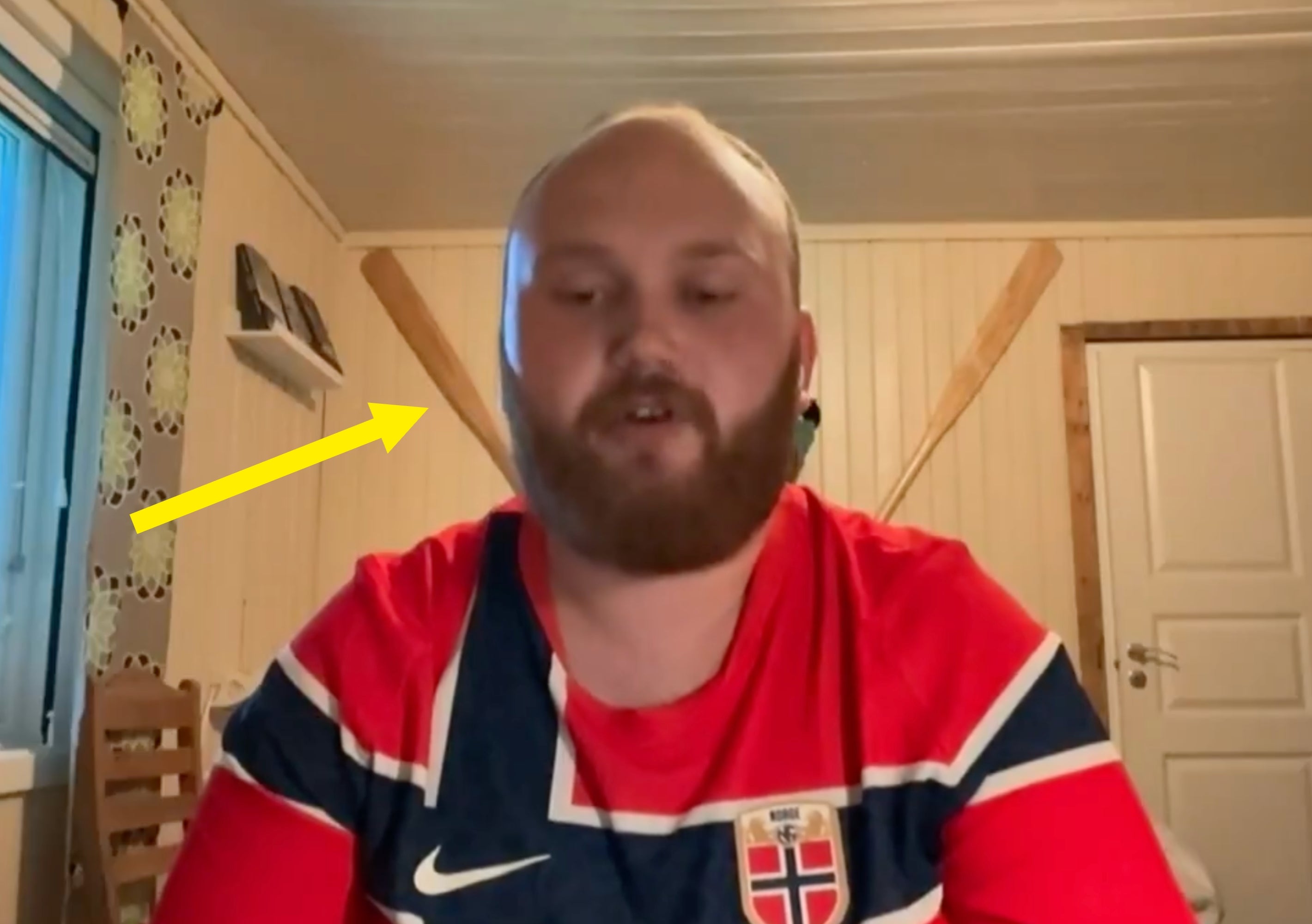 Person i sportstrøye med årer på veggen bak seg i et koselig rom