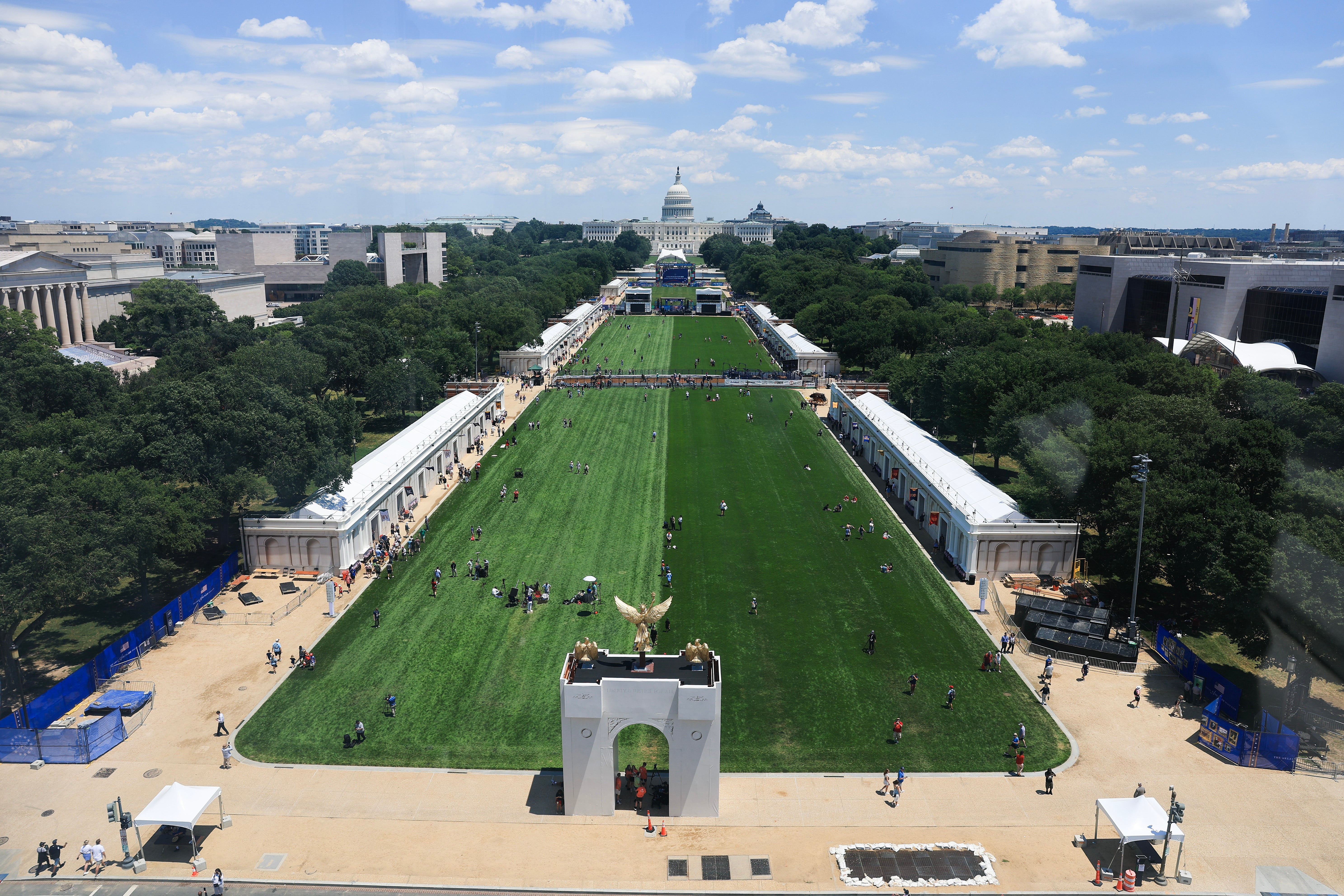 Luftfoto av National Mall med Capitol i bakgrunnen, med et stort grønt felt med folk som går og samles