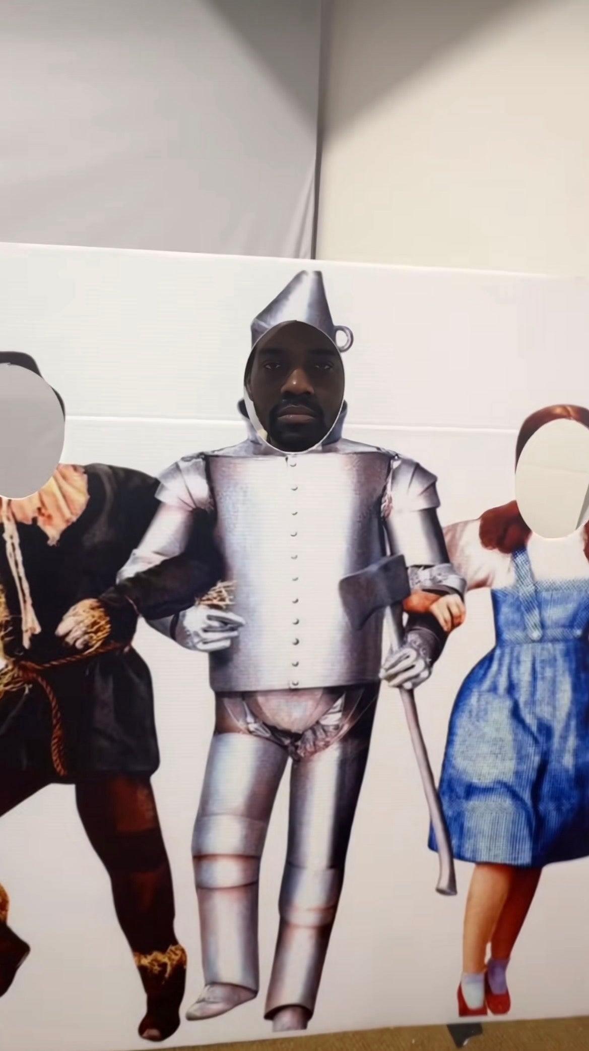 En person poserer med ansiktet i et utklipp av Tin Man fra 