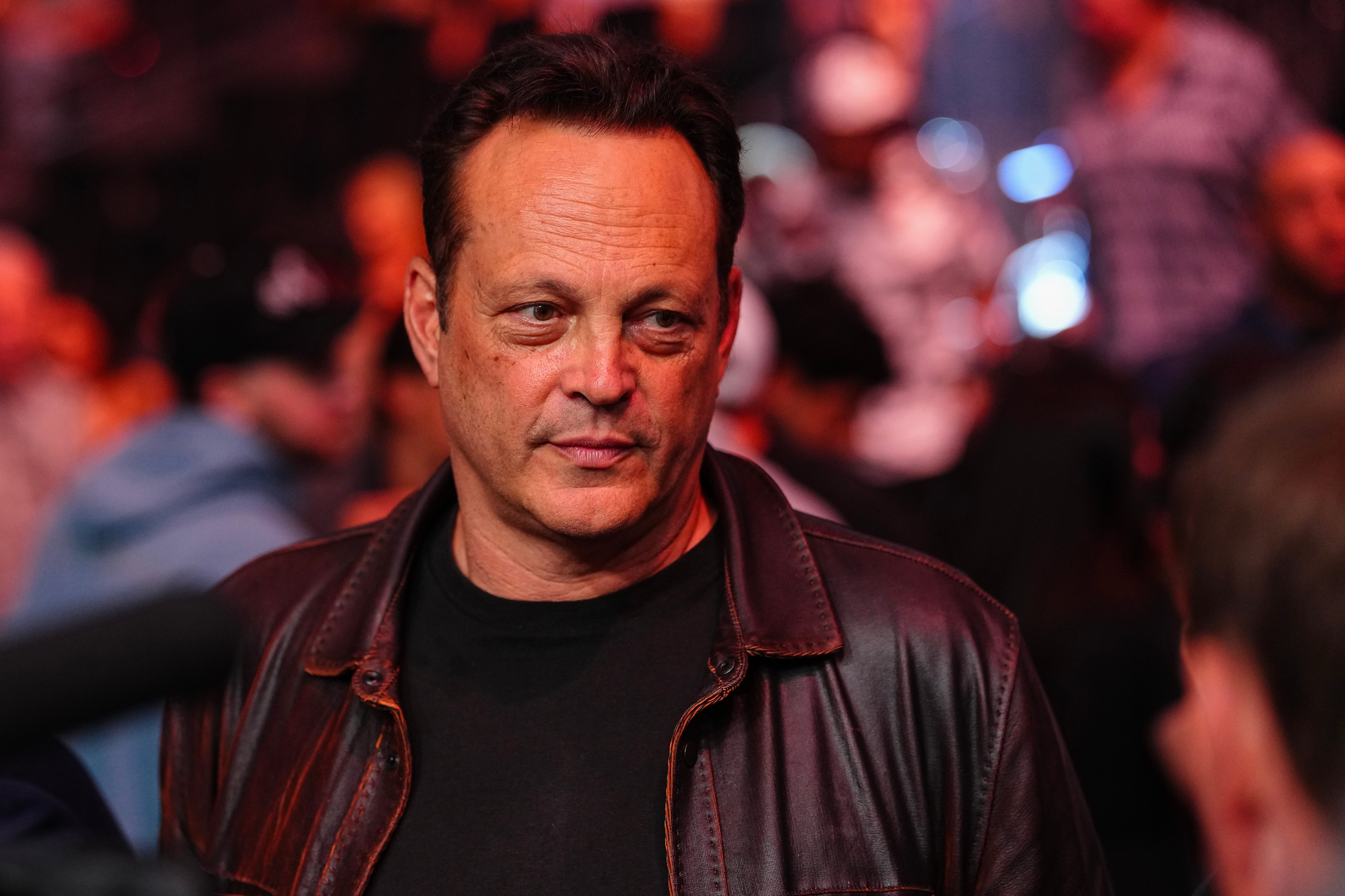 Vince Vaughn in a leather jacket is present at a public event, surrounded by a crowd