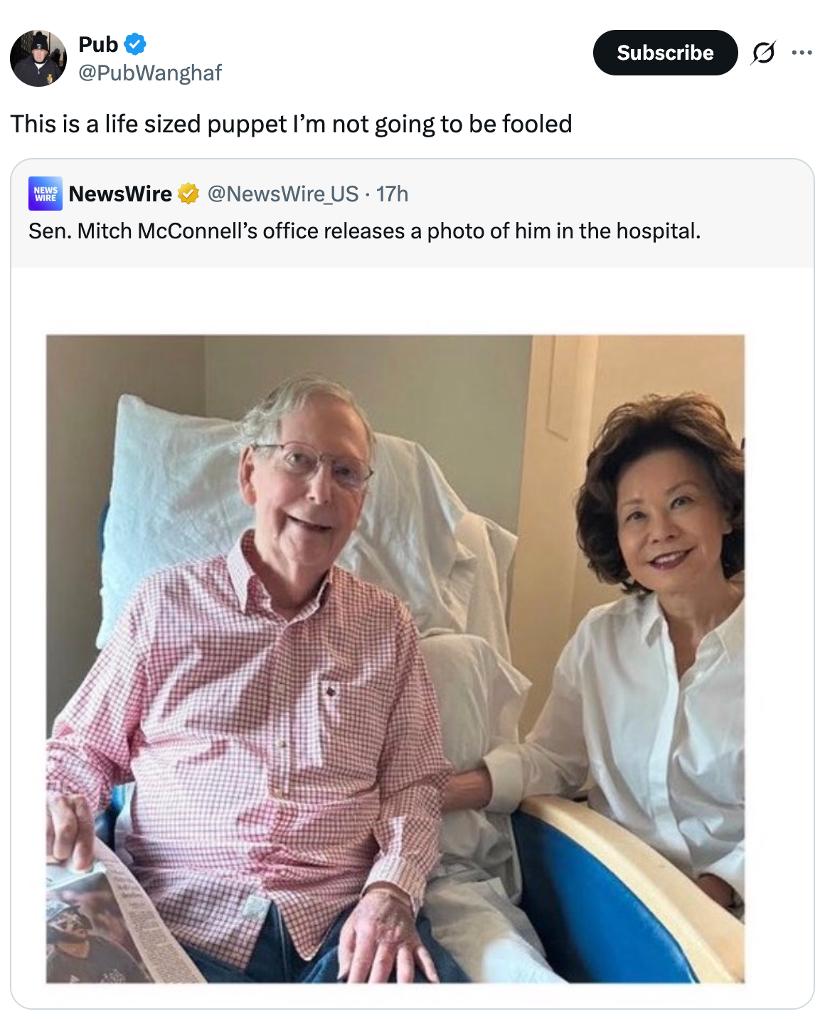 An elderly man in a hospital setting sits beside a woman. The tweet comments on him resembling a life-sized puppet
