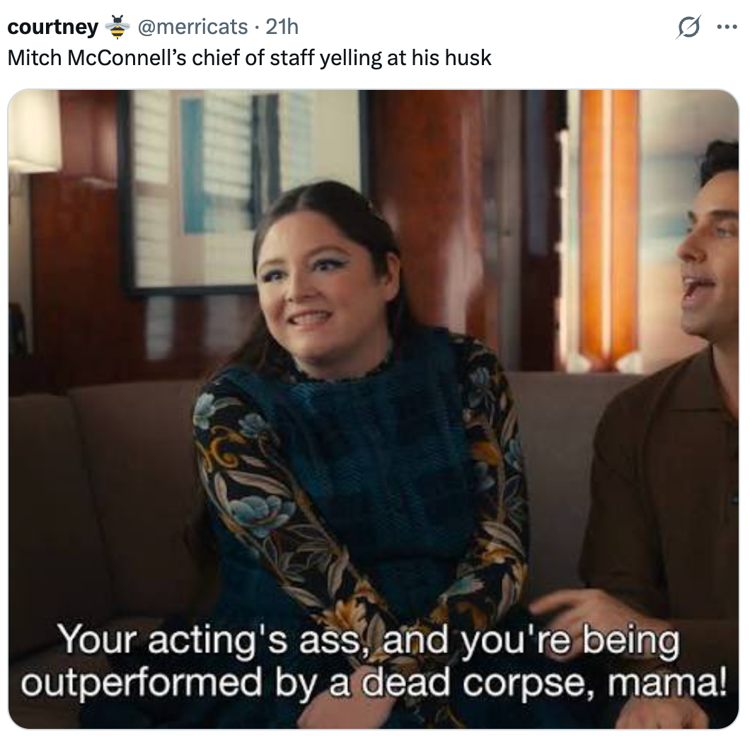 A woman in a floral dress smiles while seated next to a man, with humorous text about acting and a dead corpse displayed below