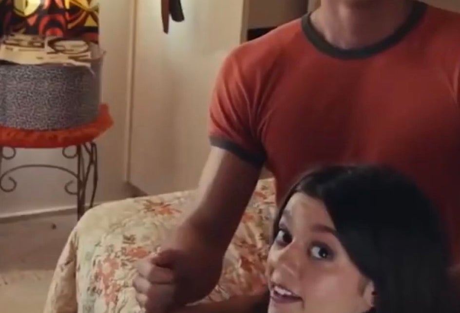 Jacob Elordi in a fitted t-shirt with a surprised expression in a room with posters on the wall