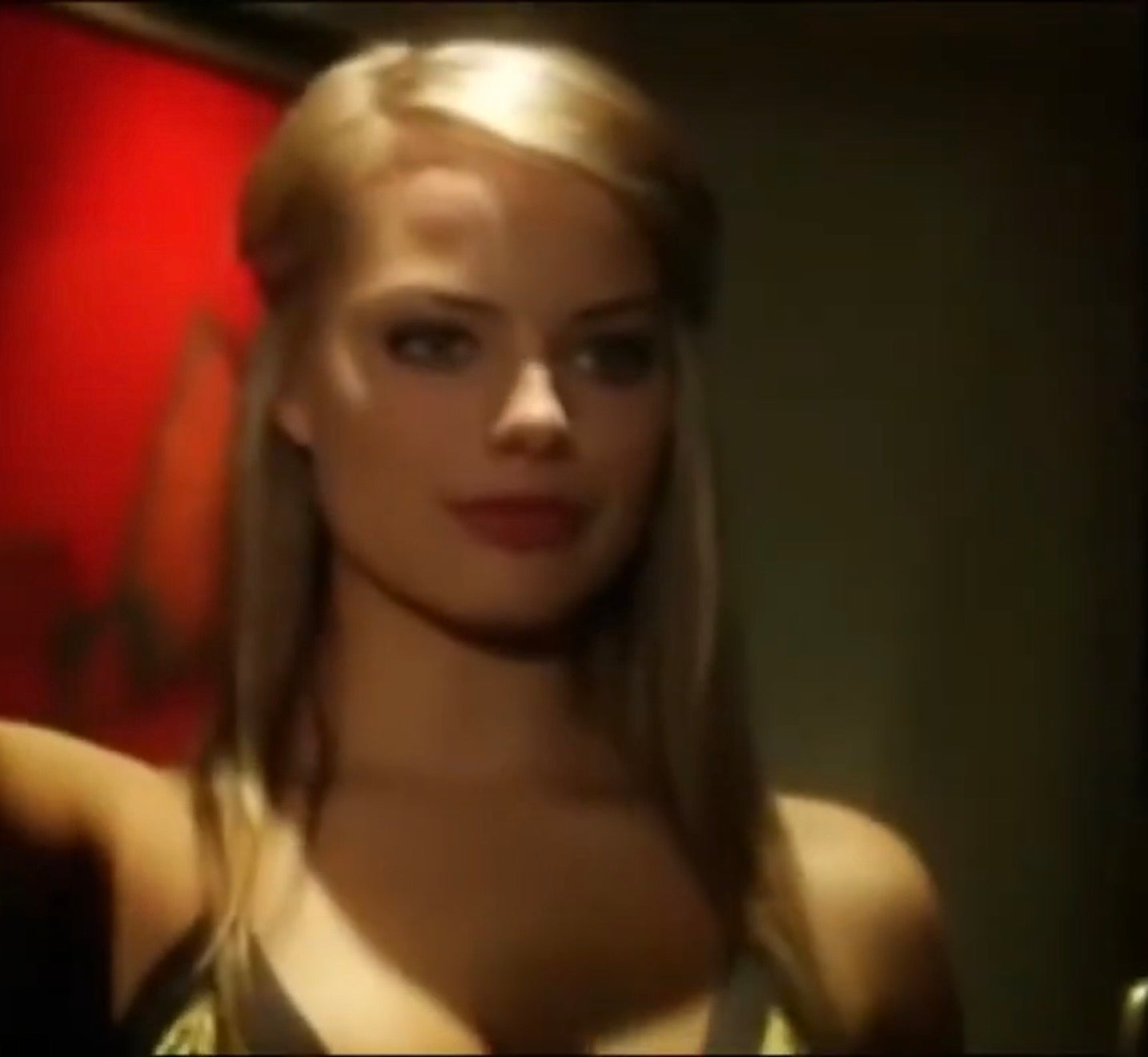 Margot Robbie posing with a serious expression, wearing a stylish sleeveless outfit, in front of an abstract background