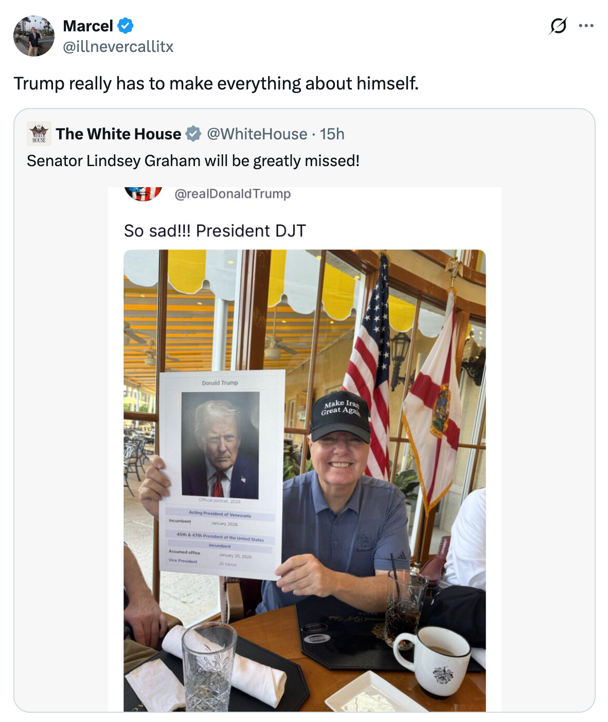 Seorang pria memegang foto Donald Trump dengan tulisan 