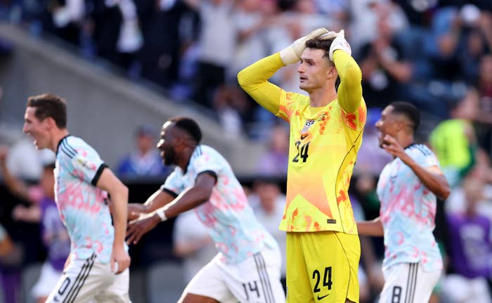 Soccer subordinate    successful  yellowish  kit holding caput  successful  disbelief, portion    teammates successful  jerseys observe  energetically connected  the field