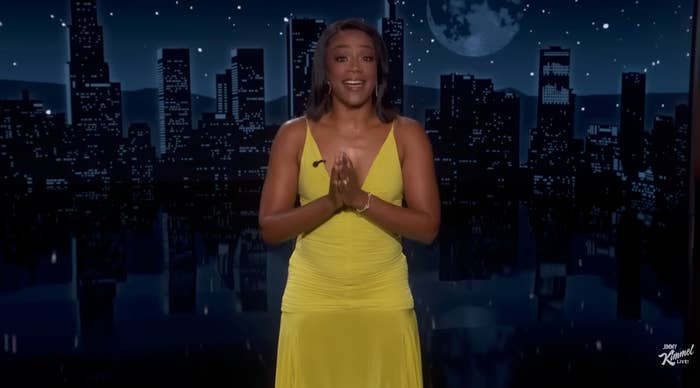 Person successful  a sleeveless evening gown onstage, cityscape backdrop with satellite  and stars