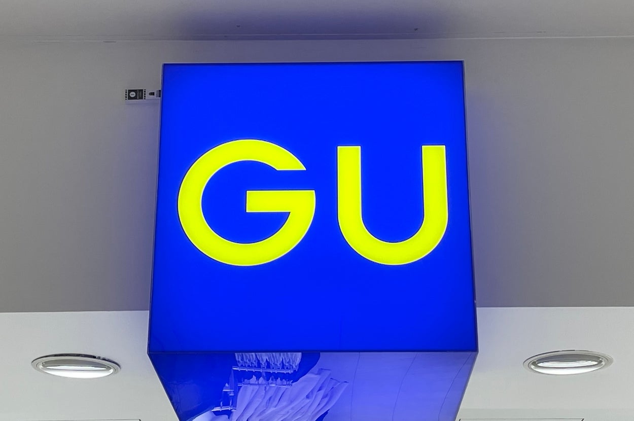GUの店の看板が壁に取り付けられている様子。