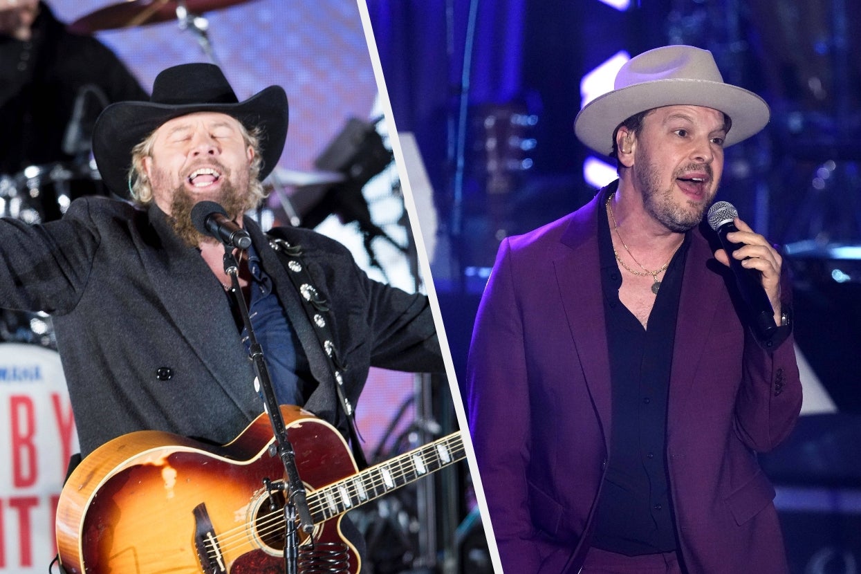 Two musicians performing live: one in a black cowboy hat and coat with a guitar, the other in a fedora and maroon suit singing
