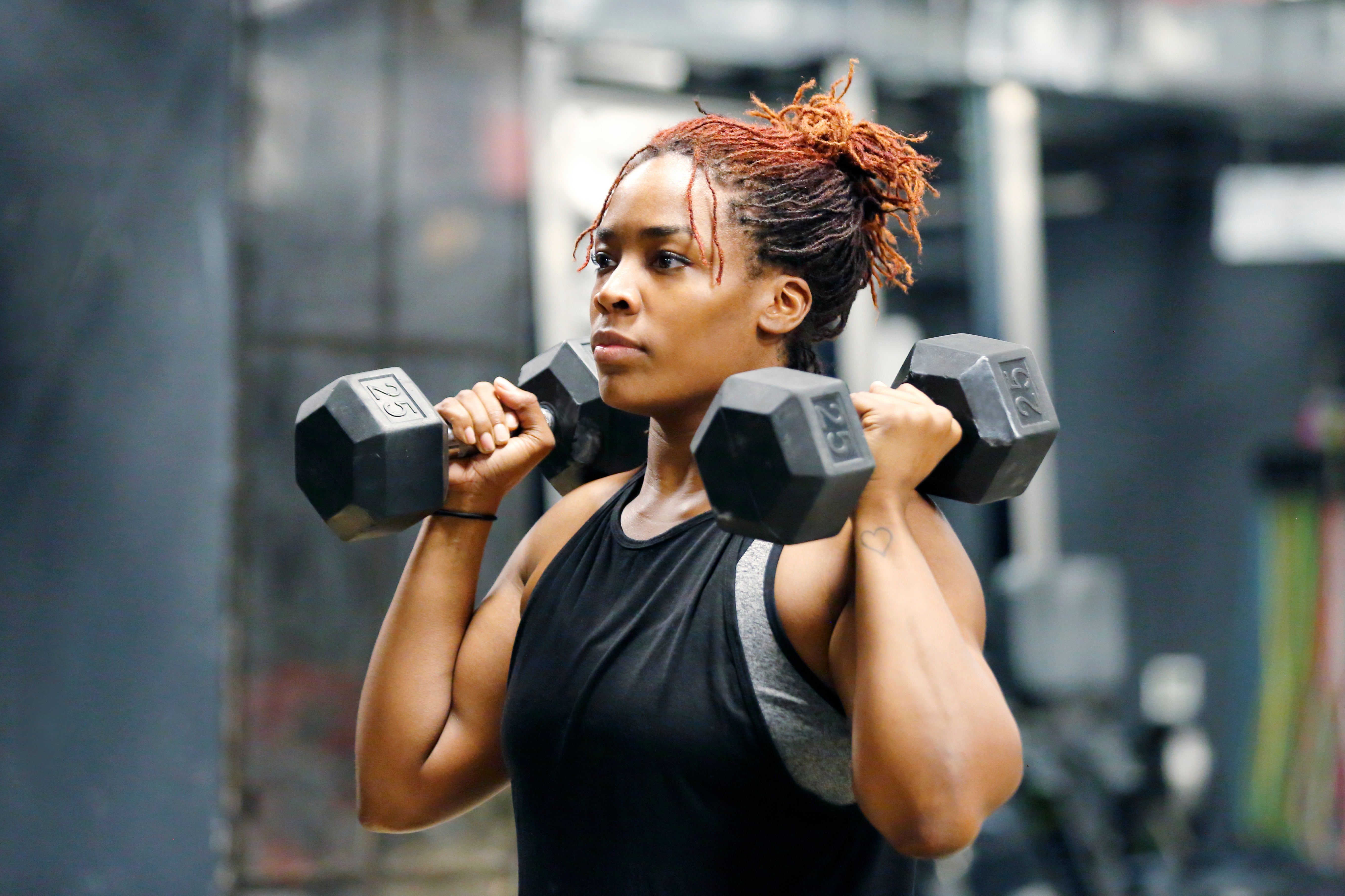 A idiosyncratic   successful  diversion  deterioration  lifts dumbbells successful  a gym, focused connected  their workout
