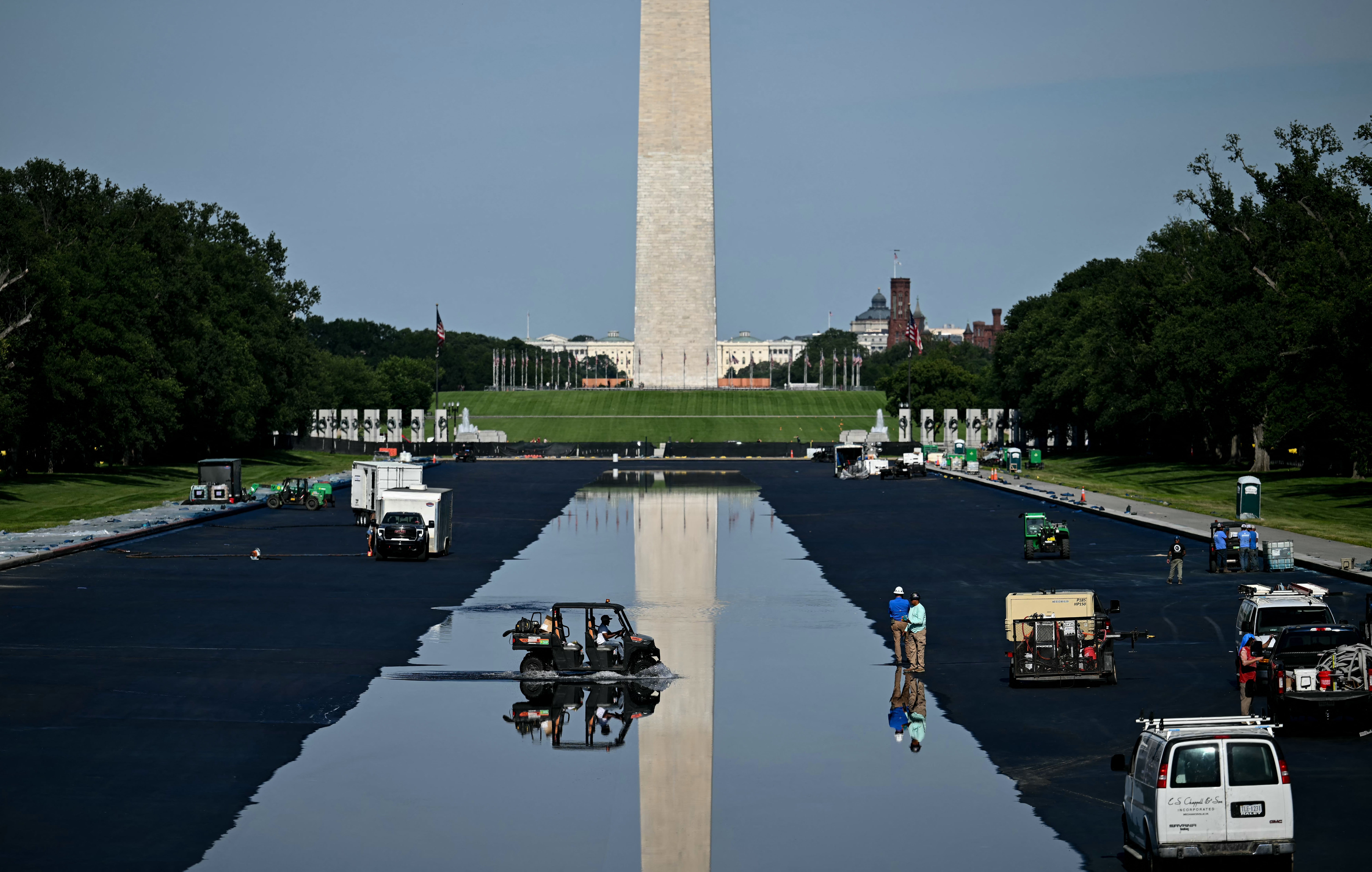 Arbeidere renser det reflekterende bassenget nær Washington-monumentet, med vedlikeholdskjøretøyer rundt