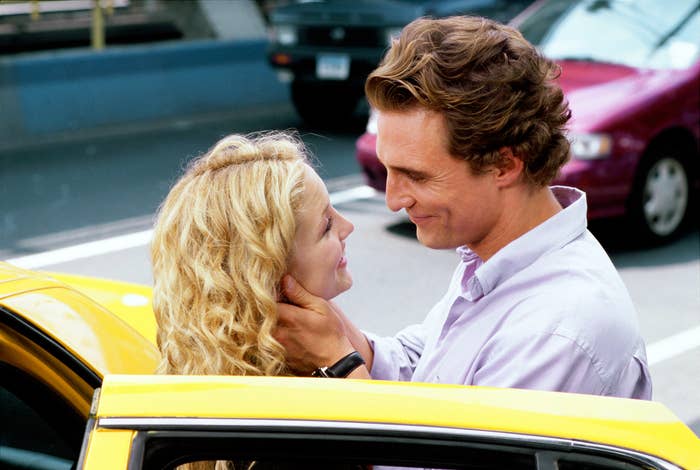 A couple shares a tender moment by a taxi, gazing lovingly into each other's eyes