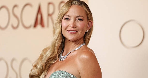 Actress in a sequined strapless gown on the red carpet, smiling for photographers