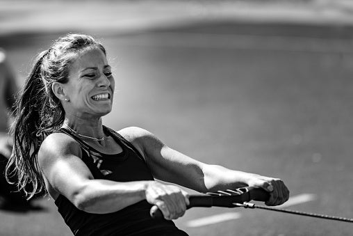 Person intensely rowing successful an outdoor workout setting, displaying determination and focus