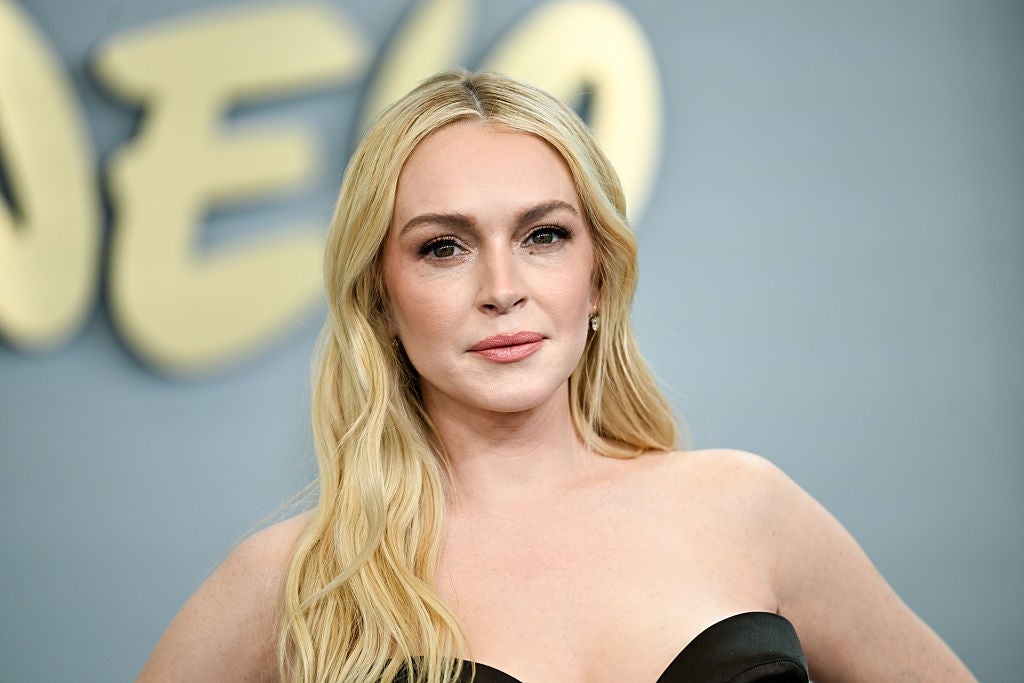 Lindsay Lohan, in a strapless dress, poses at an event