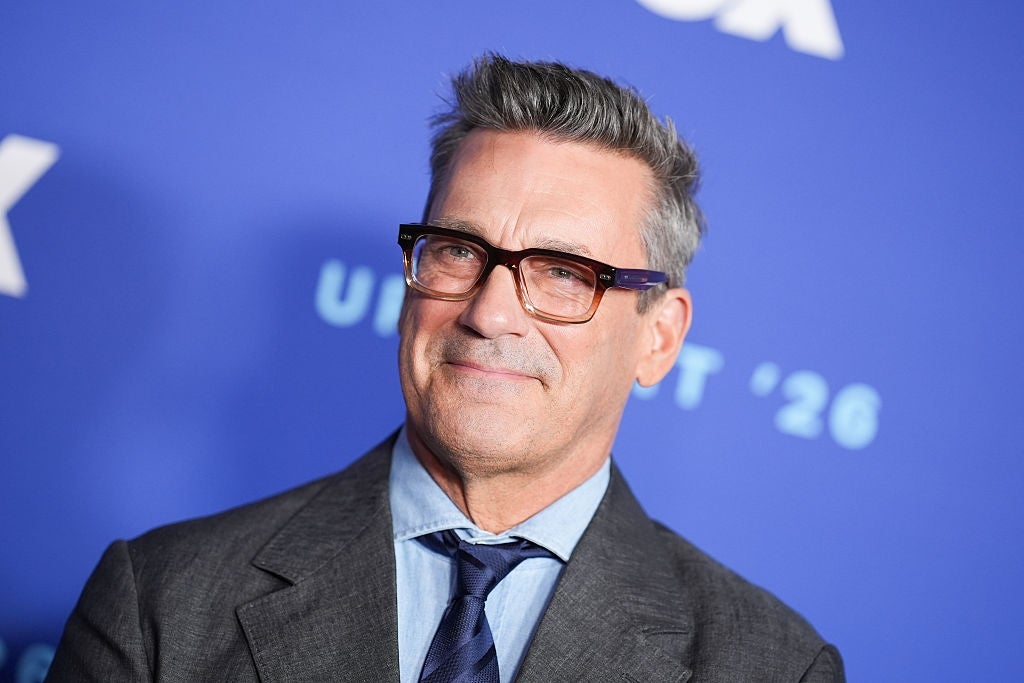 Jon Hamm in a suit with glasses at an event