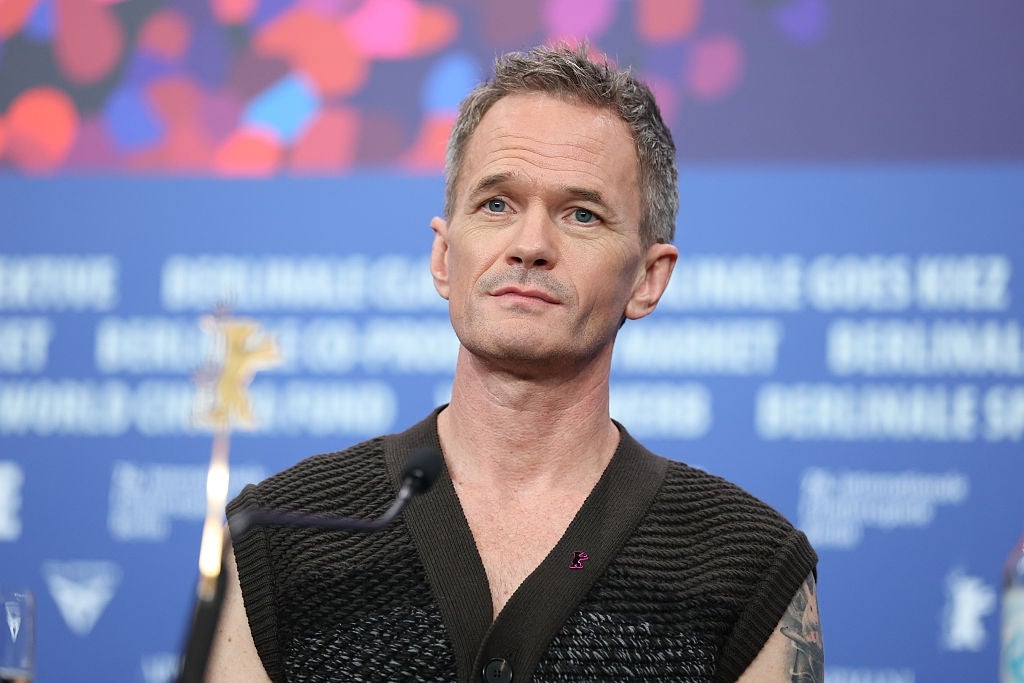 Neil Patrick Harris in a sleeveless knit top at a press event, looking thoughtful