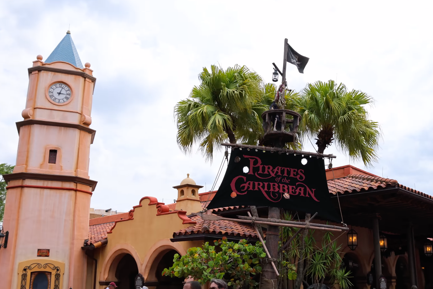 Pirates of the Caribbean attraction entrance with themed decor and a clock tower nearby
