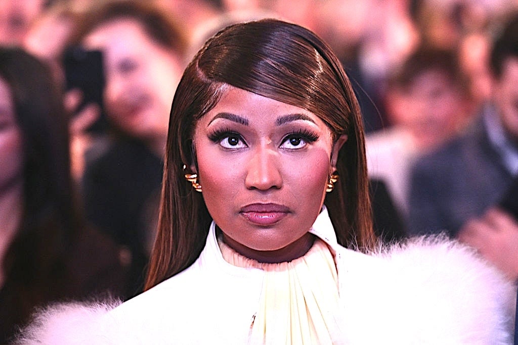 Nicki Minaj looks upwards at an event, surrounded by a crowd