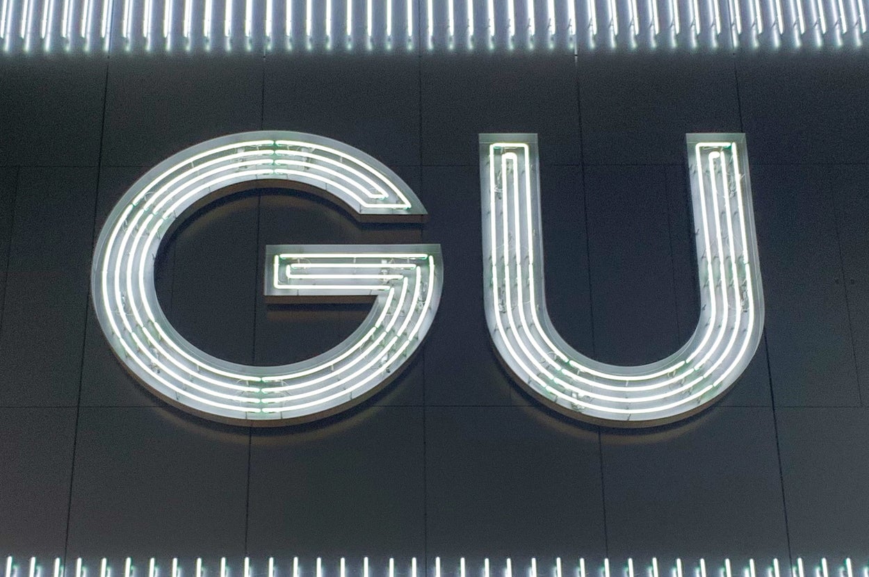 大きなネオンの「GU」の看板が壁に取り付けられている。