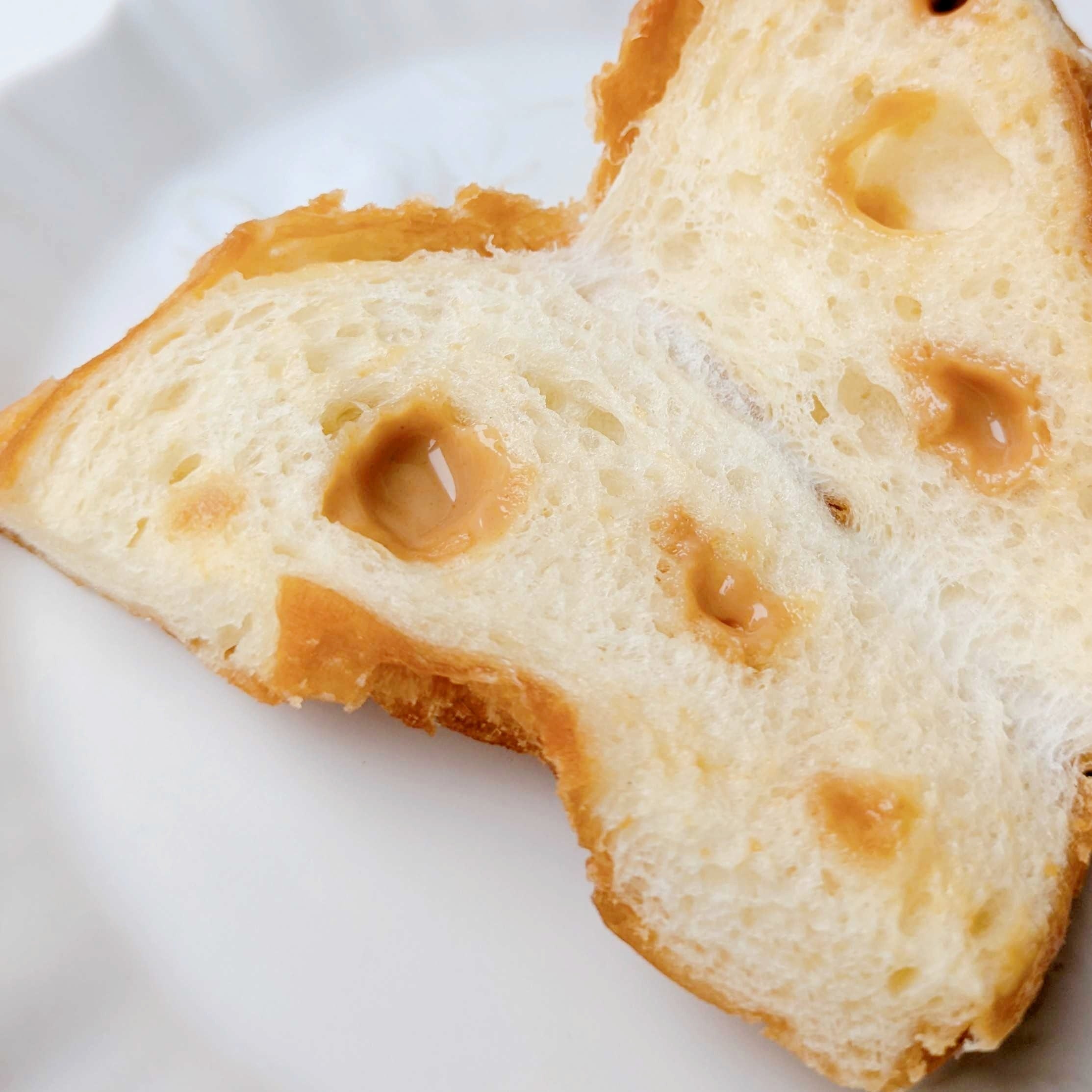 ファミリーマート「も～っちり食感きなこドーナツ」きなこクリームが入っているドーナツの断面。