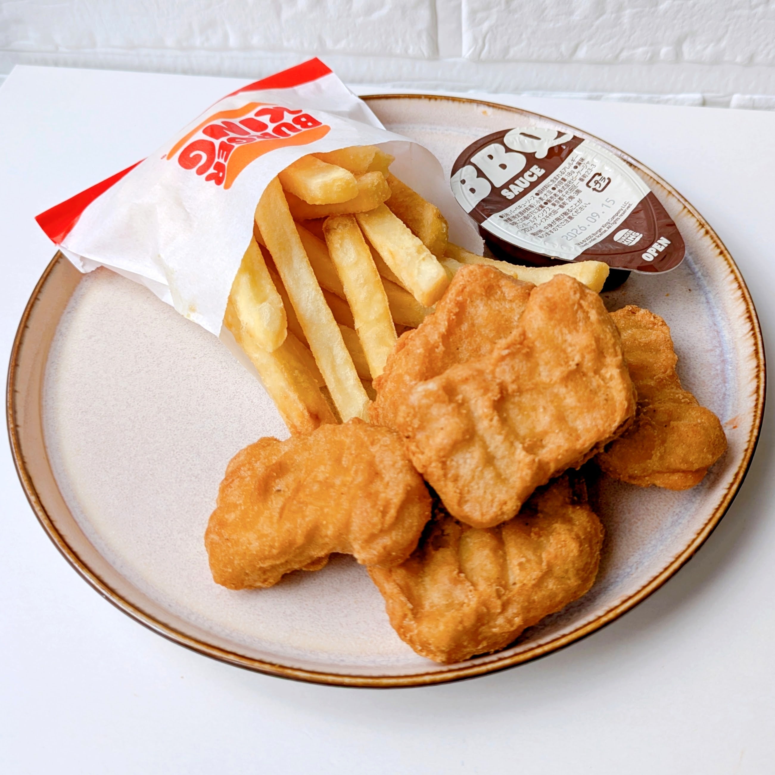 バーガーキングの「All DAY KING MEAL アボカドワッパーJr.」皿にフライドポテトとチキンナゲット、バーベキューソースが添えられています。