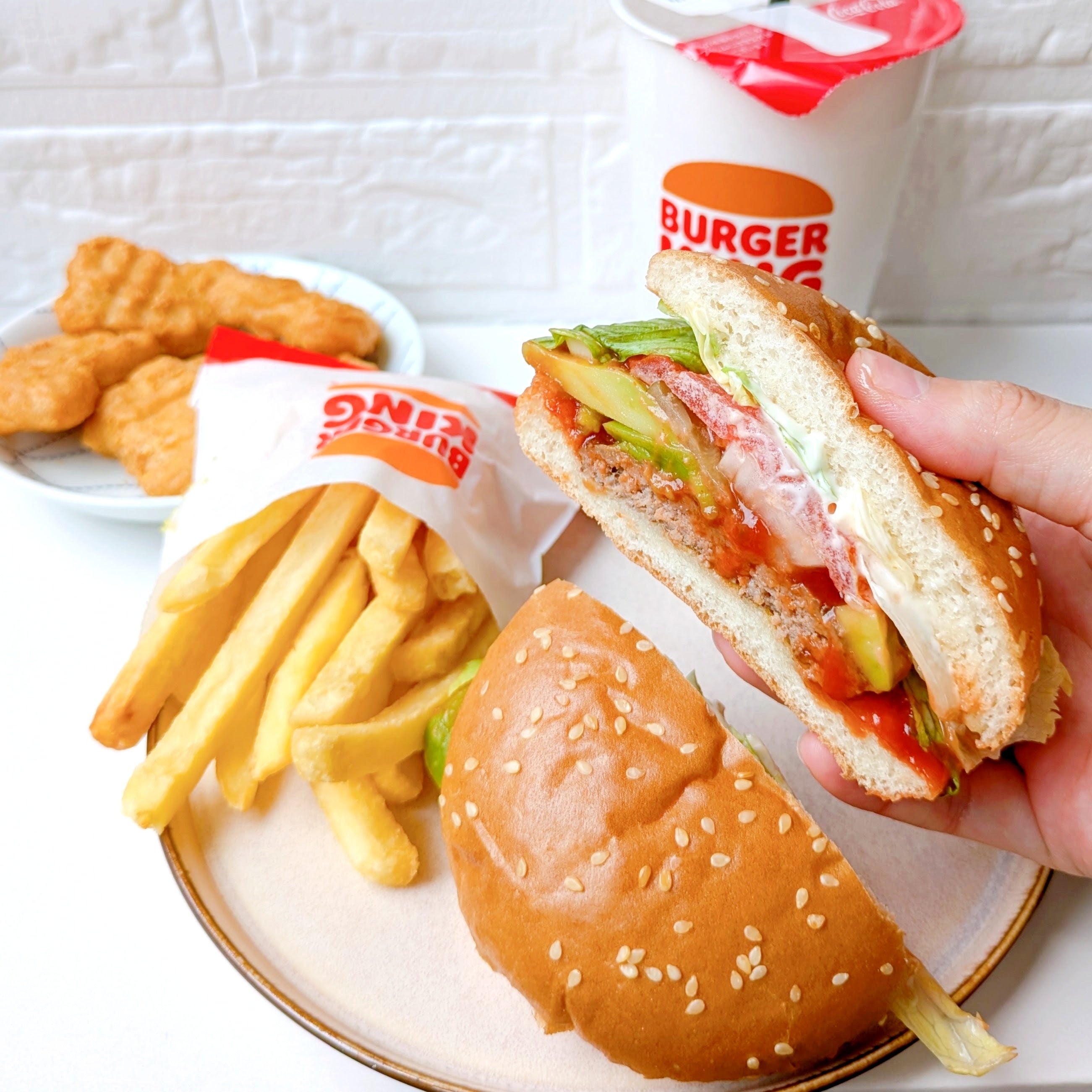 バーガーキングの「All DAY KING MEAL アボカドワッパーJr.」ハンバーガー、ポテト、チキンナゲット、ドリンクが並ぶファストフードのセット。