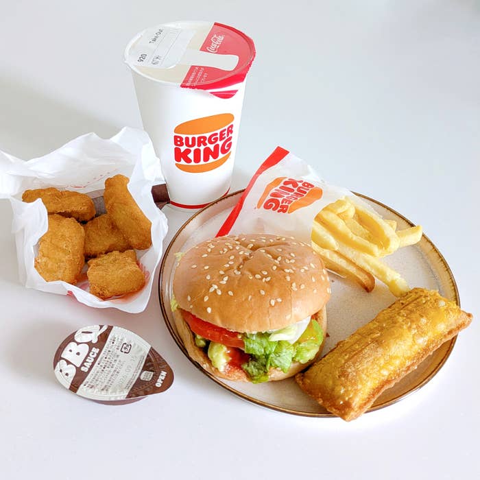 バーガーキングの「All DAY KING MEAL アボカドワッパーJr.」バーガーキングのチキンナゲット、ハンバーガー、フライドポテト、ドリンクがテーブルに並んでいる。