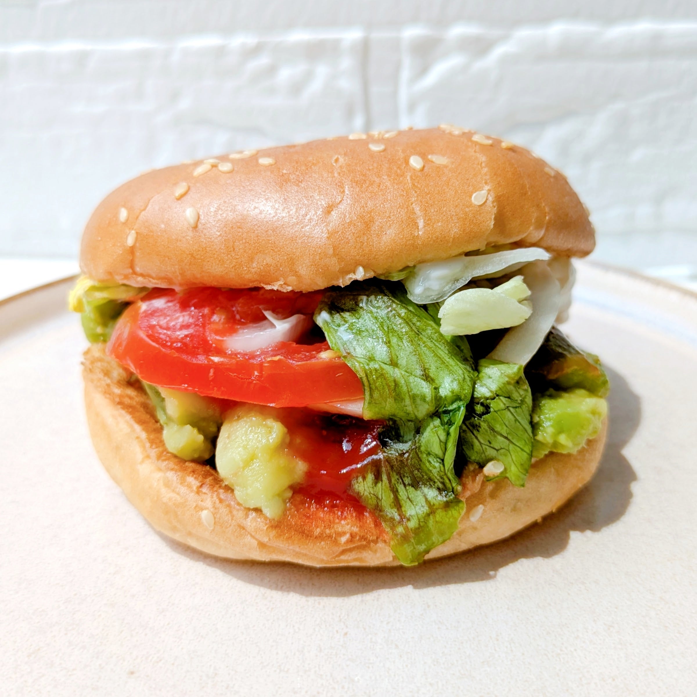 バーガーキングの「All DAY KING MEAL アボカドワッパーJr.」ハンバーガーにレタス、トマト、アボカドが挟まれている。