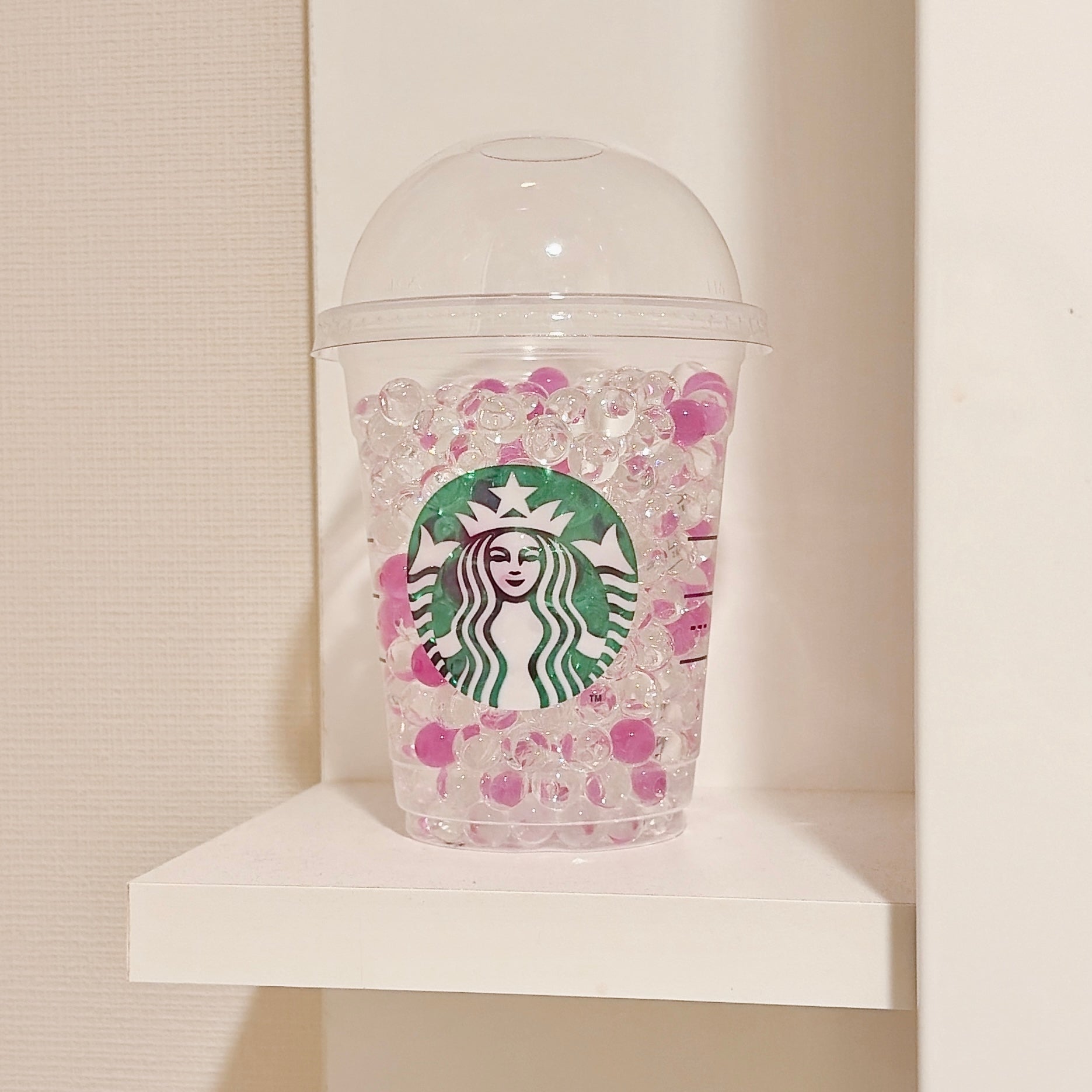スターバックスのロゴが付いたカップに消臭ビーズがぎっしり入っている様子。