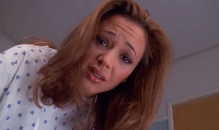 Person successful  patterned infirmary  gown, looking down   with a acrophobic   expression, arsenic  if addressing someone. Background shows a glimpse of a door