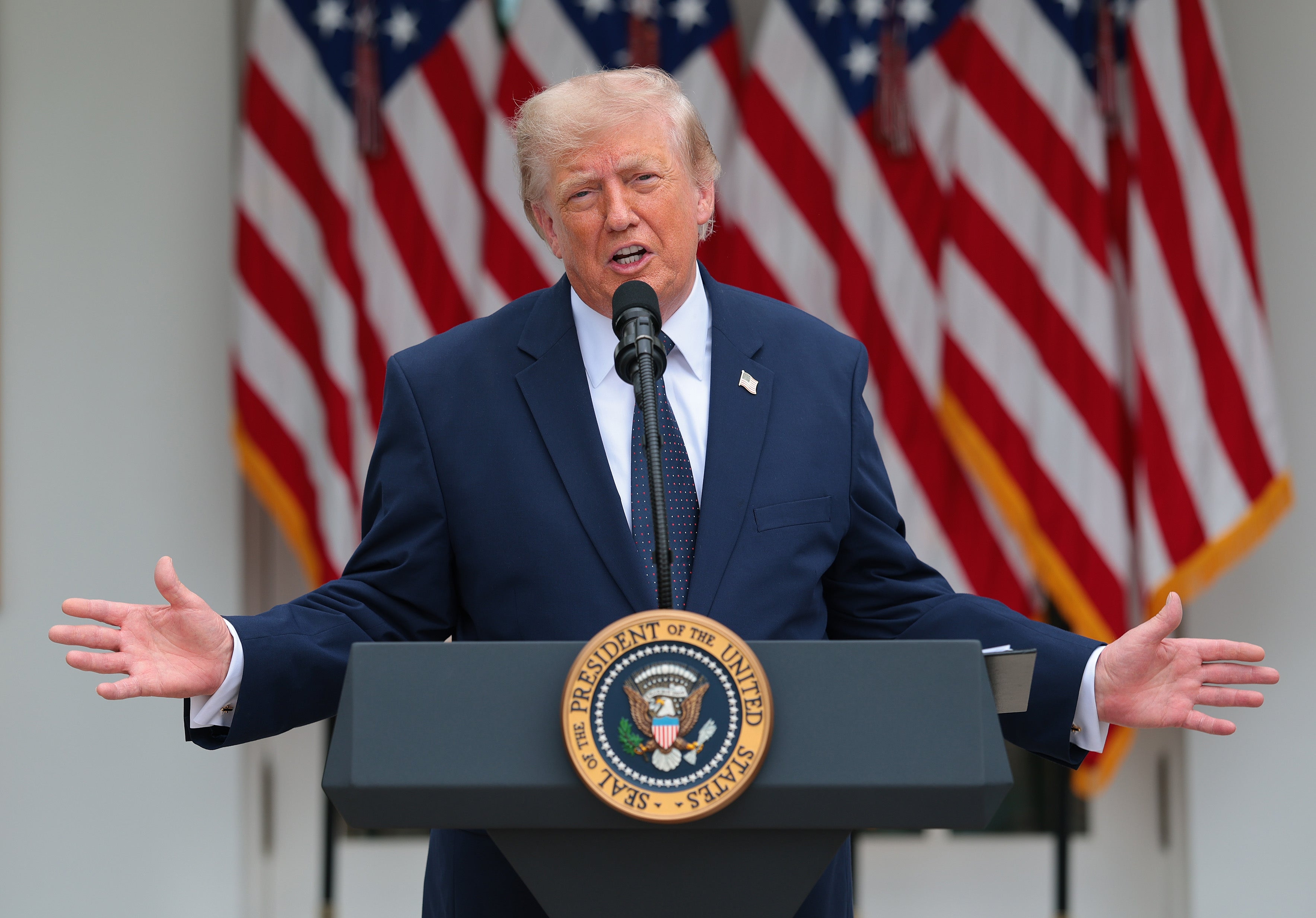 Person speaking astatine a podium with the U.S. statesmanlike seal, successful beforehand of aggregate American flags