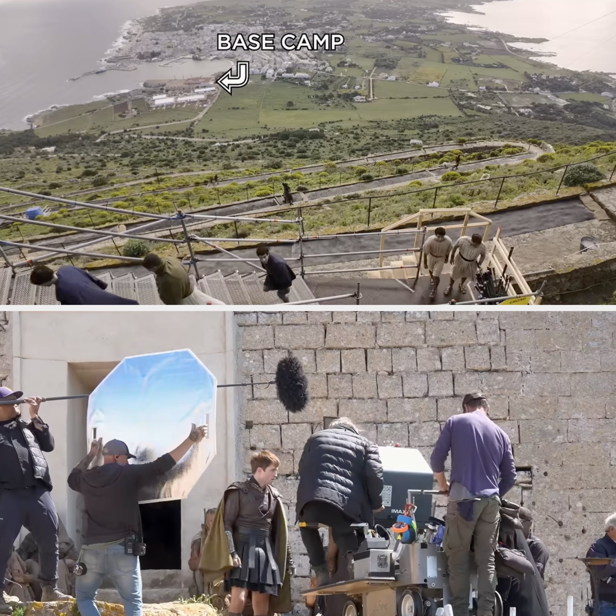 Behind-the-scenes look at a film set on a hillside with crew members, equipment, and a view of the base camp in the distance