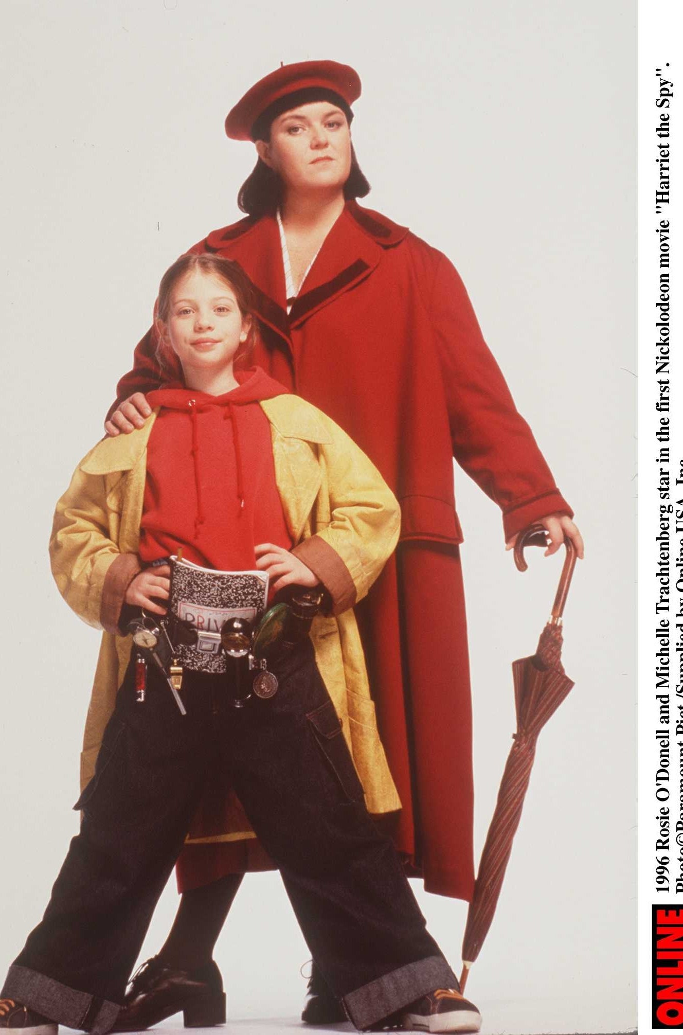 Rosie O'Donnell in a coat and hat with an umbrella in hand and Michelle Trachtenberg in a hoodie, baggy pants, and coat for Harriet the Spy