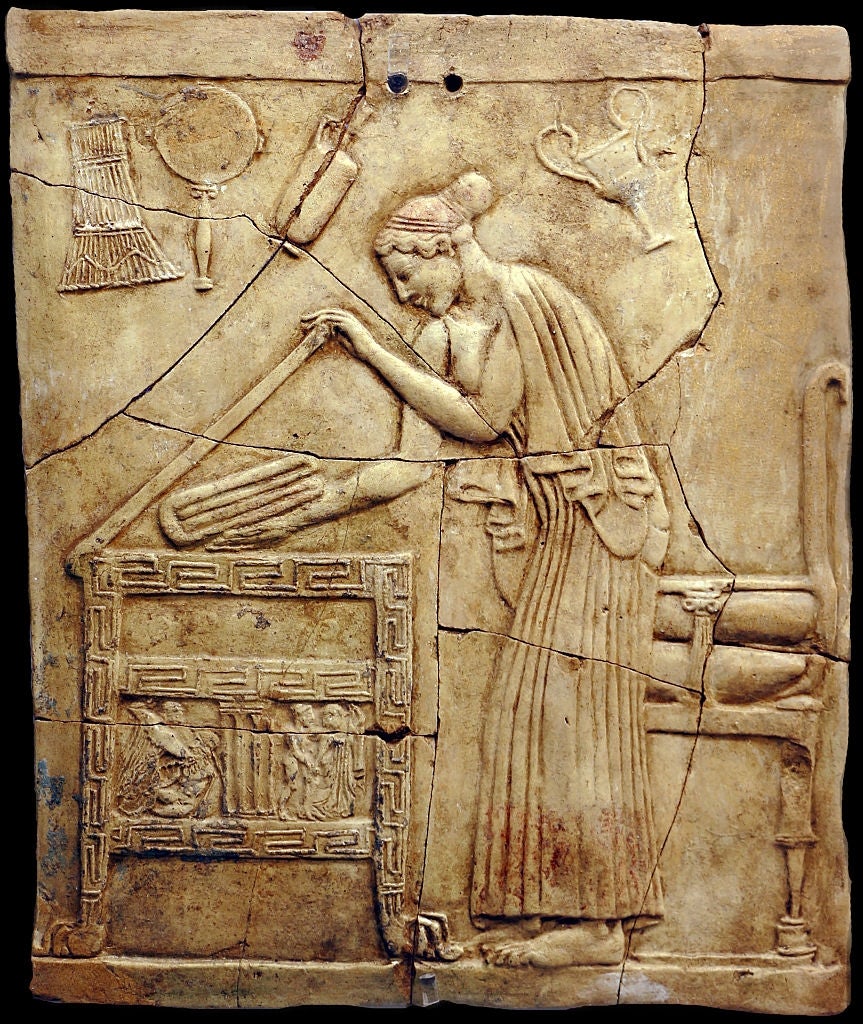 Ancient relief depicting a woman weaving or working at a loom, with tools and a chair around her