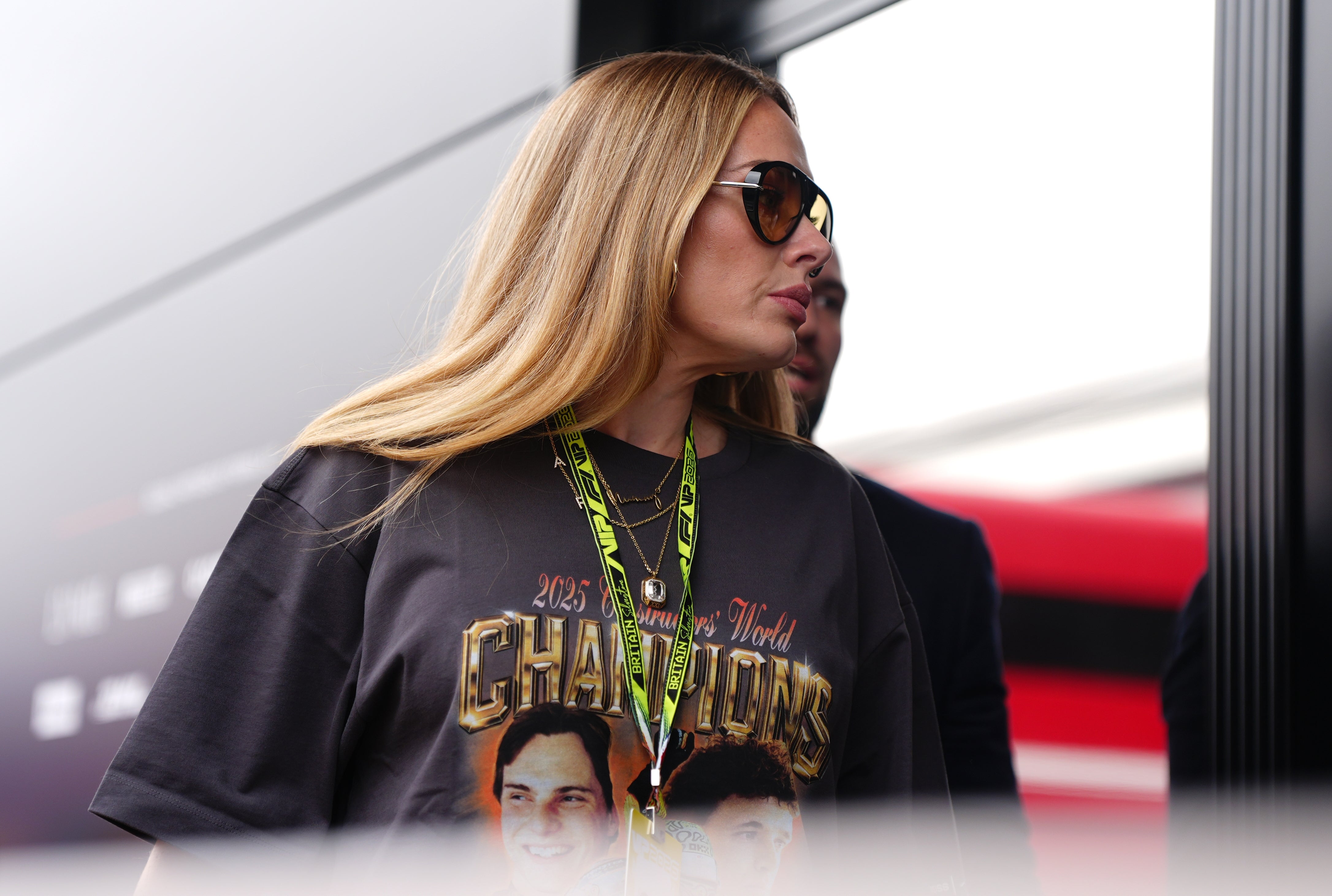 Adele wearing sunglasses and a graphic T-shirt featuring faces and "Champions" text, outdoors at an event