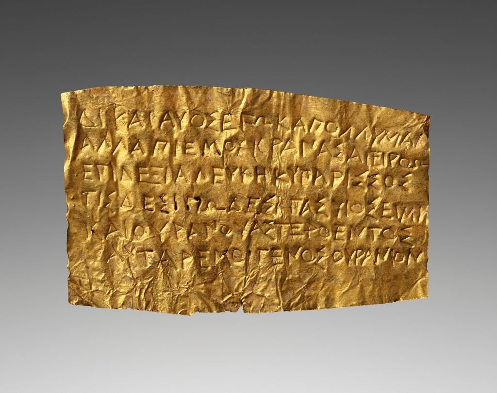 Ancient Greek gold leaf with engraved text, possibly a poetic or religious inscription, displayed against a plain background