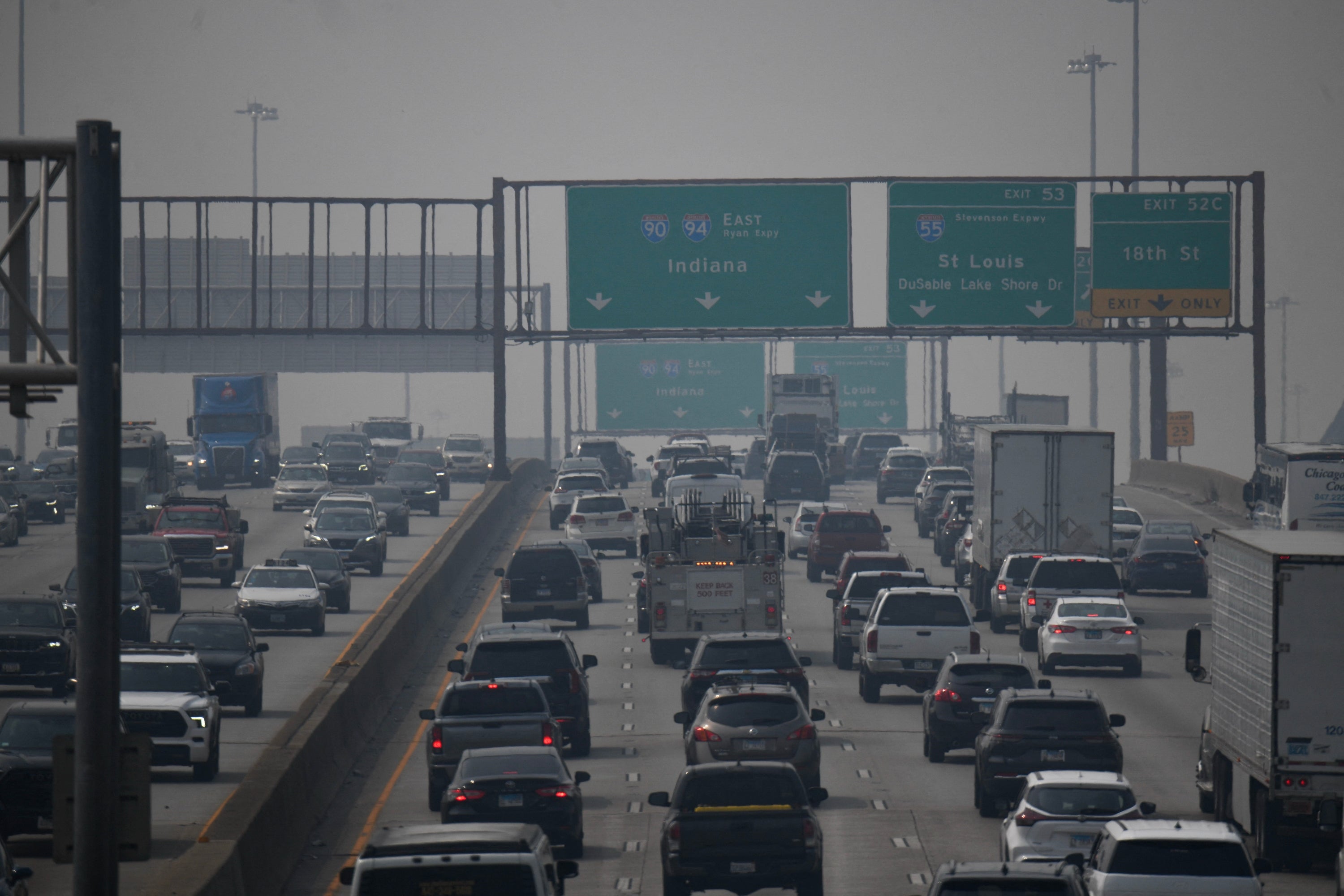 Tung trafikk på en trafikkert motorvei med flere kjørefelt, veiskilt over hodet som viser veibeskrivelse til Indiana og St. Louis