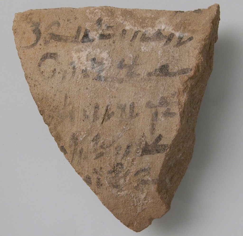 Ancient pottery shard with faded writing in an old script