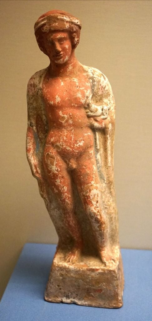 Ancient Greek terracotta statue of a nude male figure, possibly depicting a god or athlete, standing on a base
