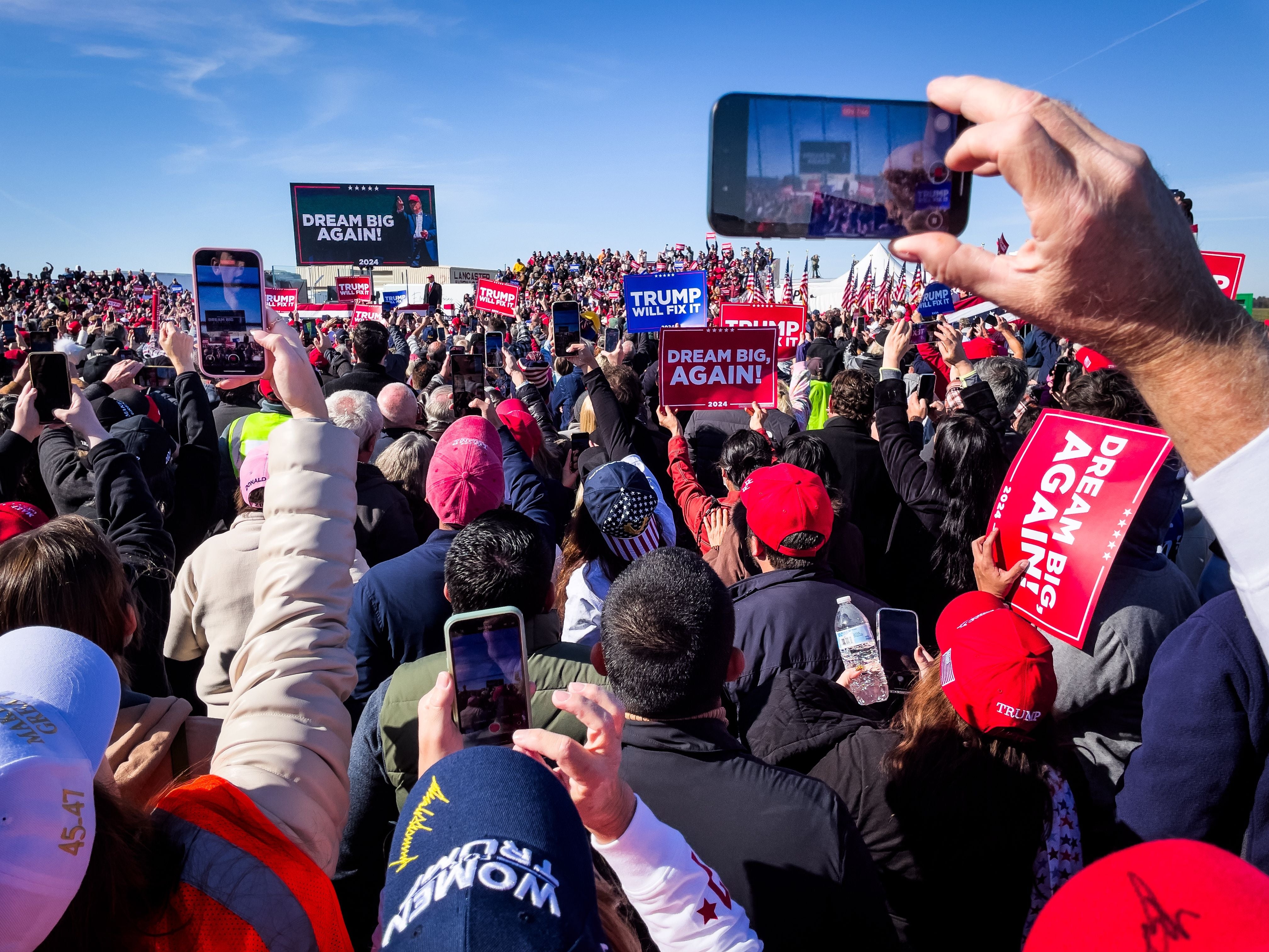 Et stort publikum på et rally holder skilt som